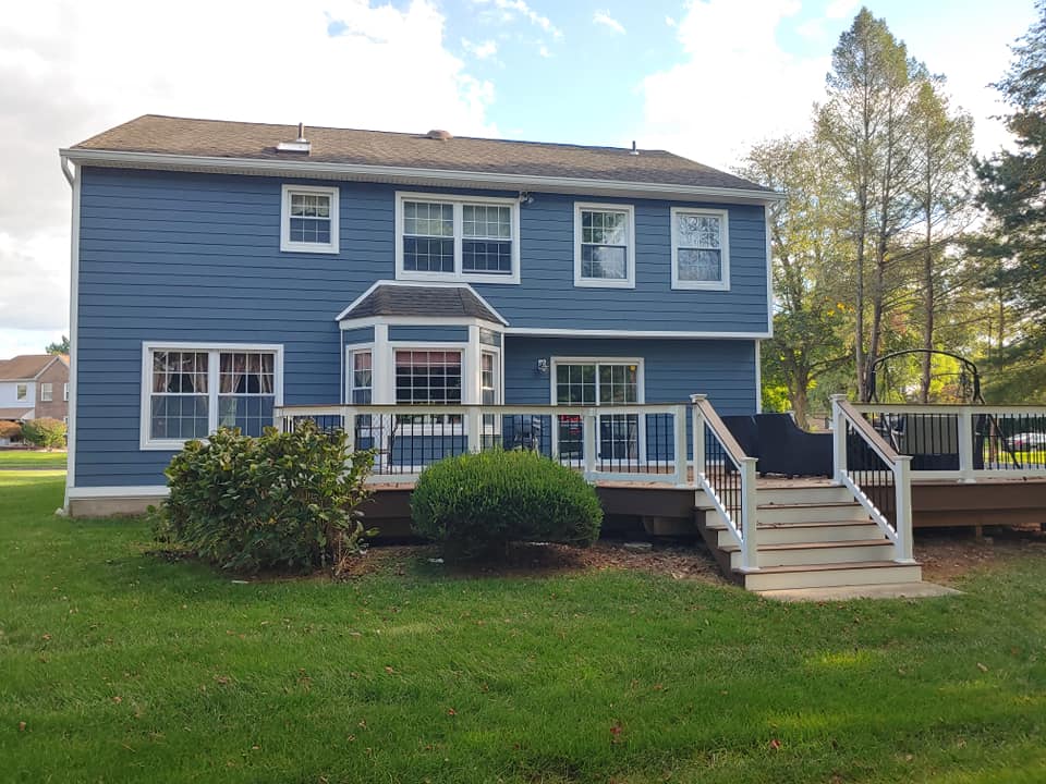 KPI Blue house with wide deck A multi-level composite deck is ideal for a sloped or terraced backyard.