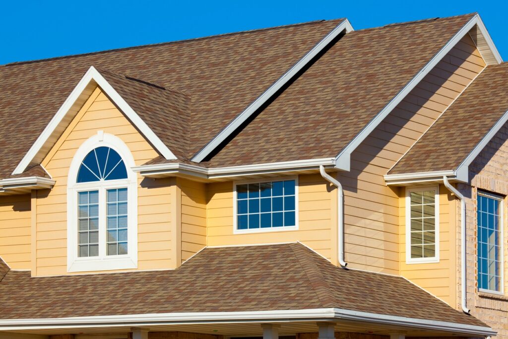 House With Yellow Vinyl Siding, New Roof Our shingle roofing is versatile, affordable, and durable.