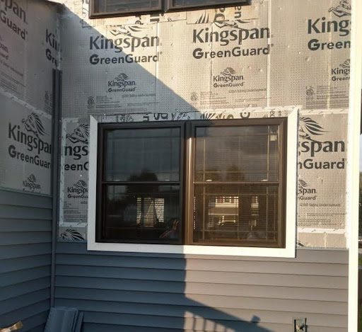 KPI Jr Exteriors crew inspecting exposed sheathing and installing a water-resistive barrier during a siding replacement